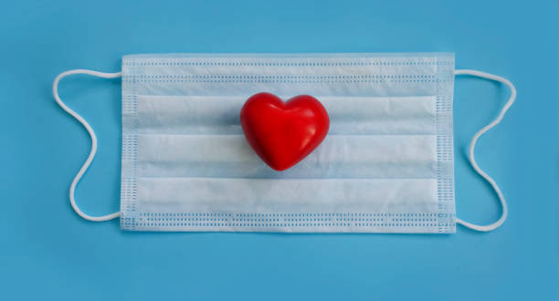 istock medical mask, heart on a colored background 1339832713