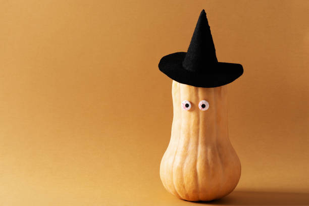 istock Funny pumpkin with face and hat on brown 1339833261