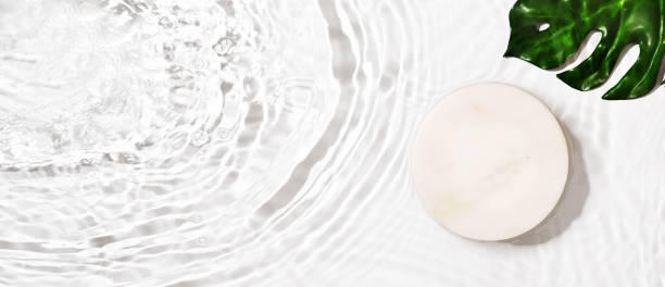 istock Transparent and clean white water background with podium and sunlight reflection 1339833290