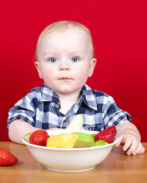 Young boy with bowl of fruit stock photo