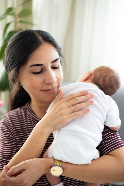 istock Happy mother burping her sleeping baby 1339835851