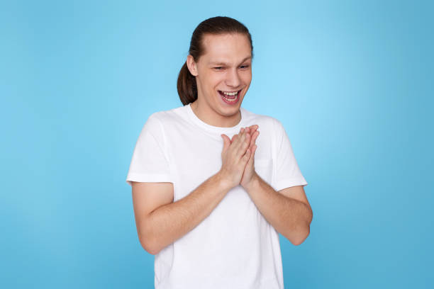 istock young handsome guy in t-shirt smiling isolated on blue background. 1339839860