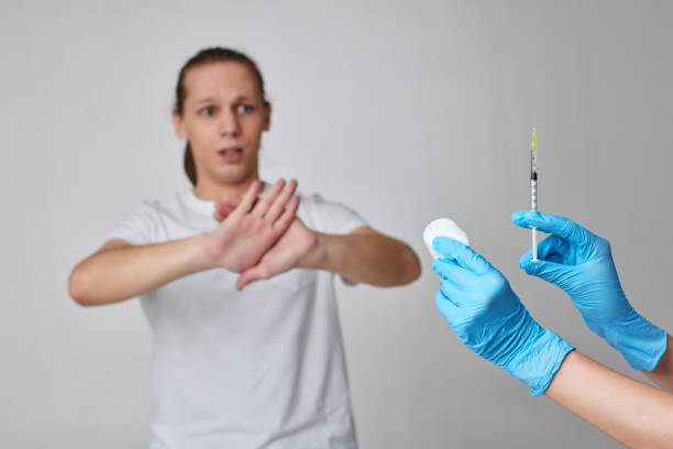 コロナウイルスワクチン接種中の怖い男性, covid-19 予防接種. - injecting syringe spooky male ストックフォトと画像