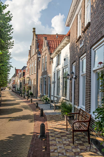 Hasselt, The Netherlands, August 11, 2021: slightly curved row of brick and plaster facades on Heerengracht canal in the old town
