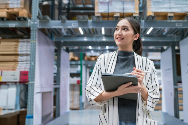 retrato de la propietaria de un negocio asiático utilizando una tableta digital que verifica la cantidad de inventario de productos en stock en el estante de la fábrica del almacén de distribución.logística negocio servicio de envío y entrega - warehouse manager place of work portrait fotografías e imágenes de stock