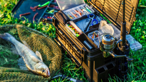 A large fisherman's tackle box fully stocked with lures and gear for fishing.fishing lures and accessories in the box background. stock photo