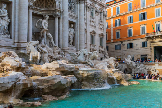 Trevi fountain on a sunny day The Trevi Fountain is a fountain in the Trevi district in Rome, Italy, designed by Italian architect Nicola Salvi and completed by Giuseppe Pannini and several others. dolce aqua stock pictures, royalty-free photos & images