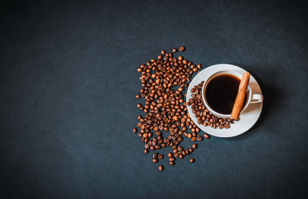 istock Coffee cup with cinnamon stick on it and coffee beans on dark background 1339862955