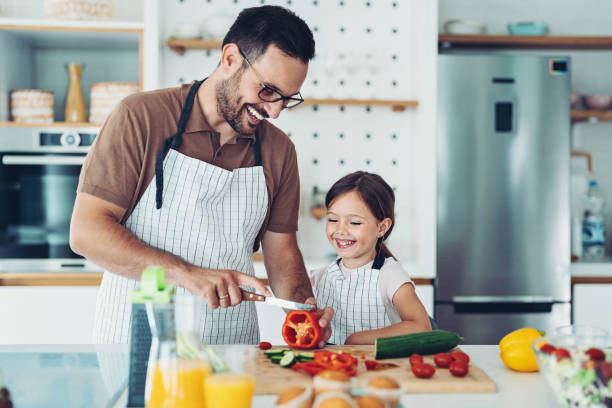 istock Father and daughter cutting peppers in the kitchen 1339864328