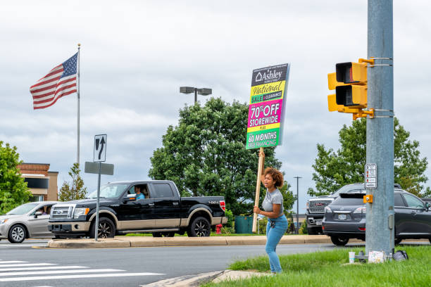 szczera kobieta trzymająca ashley homestore sklep reklama przy chodniku sklepowym w hrabstwie loudoun w stanie wirginia - strip mall shopping mall road street zdjęcia i obrazy z banku zdjęć