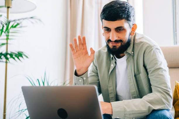 istock Young caucasian man college student studying with laptop distantly at home using video call, weaving. Distantly education concept. 1339869827