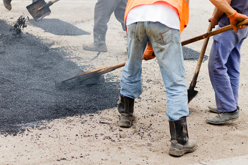 Workers on Asphalting paver machine during Road street repairing works. Creative image