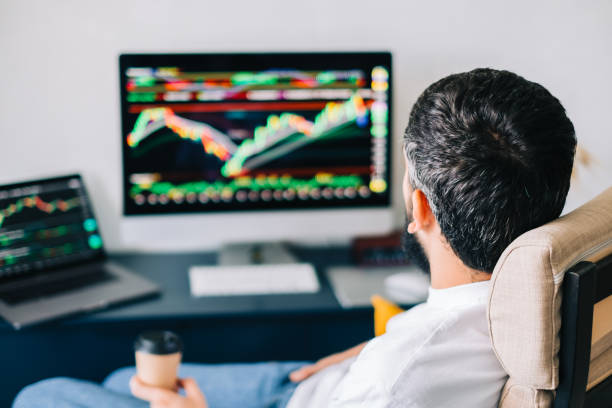 istock Caucasian businessman trading online, using computer technology, looking on stock exchange trade and analyzing 1339870111