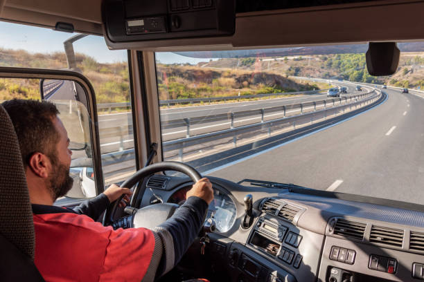 istock Truck driver driving on the highway, seen from inside the cab. 1339870224