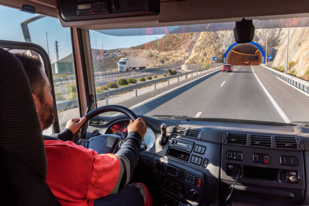 conductor de camión, visto desde el interior de la cabina, conduciendo por la autopista y en la entrada de un túnel. - teamsters fotografías e imágenes de stock