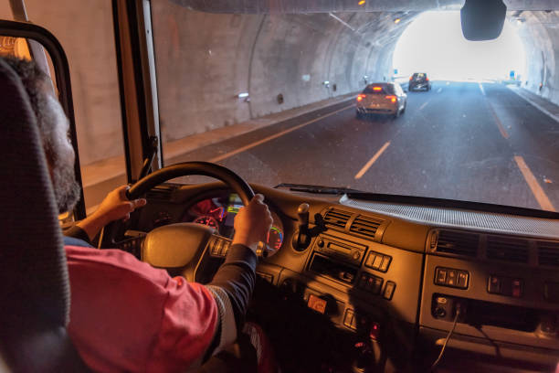 conductor de camión, visto desde el interior de la cabina, conduciendo a través de un túnel. - teamsters fotografías e imágenes de stock
