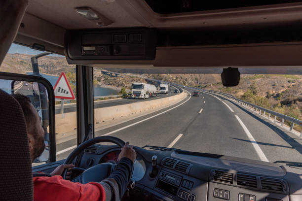 istock Truck driver driving on the highway, seen from inside the cab. 1339870268