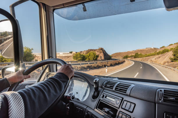 istock Truck driver driving on the highway, seen from inside the cab. 1339870282