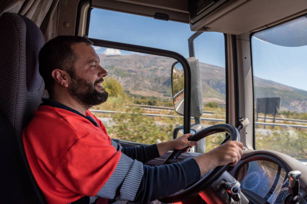 istock Truck driver driving on the highway, seen from inside the cab. 1339870289