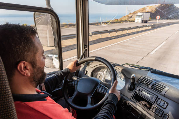 istock Truck driver driving on the highway, seen from inside the cab. 1339870290