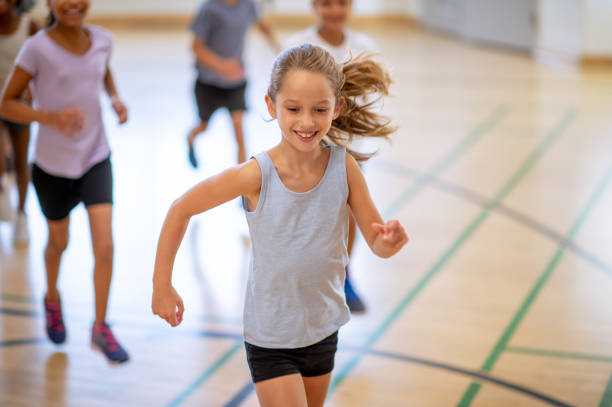 istock Caucasian girl running inside a gym during gym class 1339871078