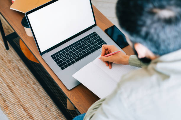 istock Caucasian man college student, studying with laptop distantly preparing for test exam writing essay doing homework at home, distantly education concept. 1339871592