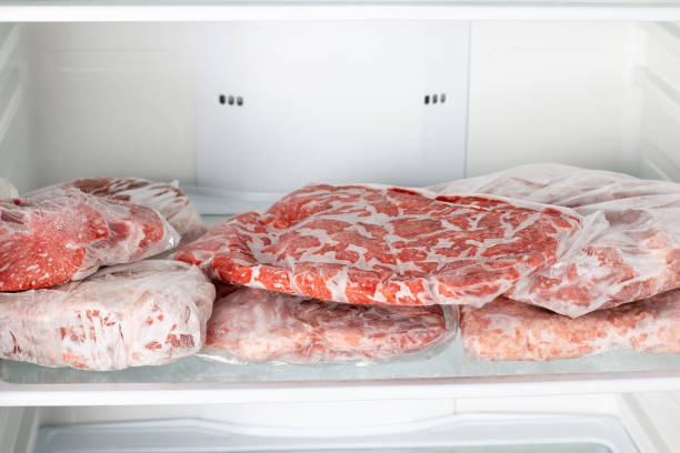 istock Frozen raw meat wrapped plastic in the freezer. 1339872612