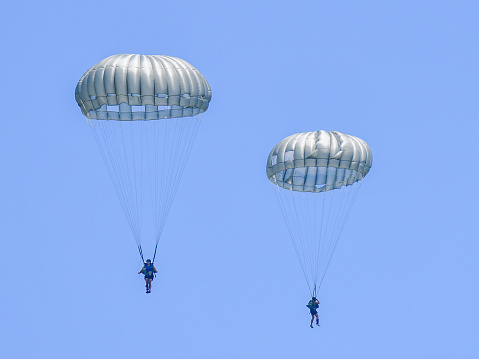 US Army  parachute jumpers of the 82nd Airborne Division are performing static line training jumps from a UH 60 helicopter into Auman Lake , operating from the Seven Lakes Community Center in North Carolina, a civilian residential neighborhood near Southern Pines.  Two paratroopers can be seen with their chutes fully deployed.\nSeven Lakes, North Carolina\n08/05/2021