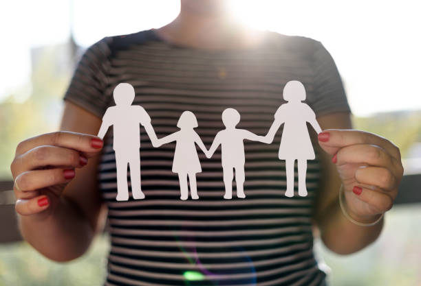 istock Hands holding family paper cut 1339872938