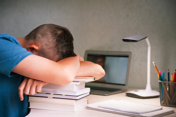 istock Teen boy napping on a stack of books 1339878044
