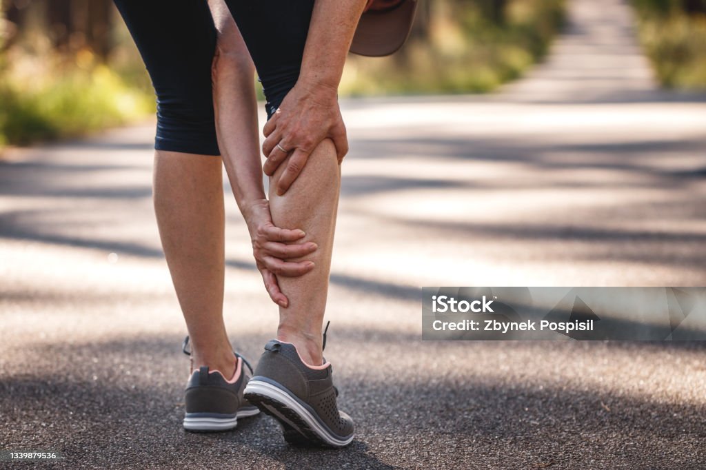Calf muscle cramp during running Woman feeling pain of her legs during jogging. Calf muscle cramp. Underestimating the warm-up exercise before running Pain Stock Photo