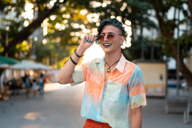 Gay man smiling outdoors Portrait of a gay man smiling in the city Pop Culture fashion stock pictures, royalty-free photos & images