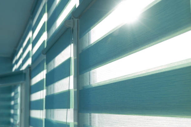 istock Close up of colored fabric roller blinds on window. Roll curtains. 1339894273