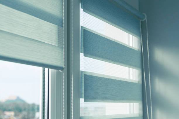 istock Close up of colored fabric roller blinds on window. Roll curtains. 1339894276