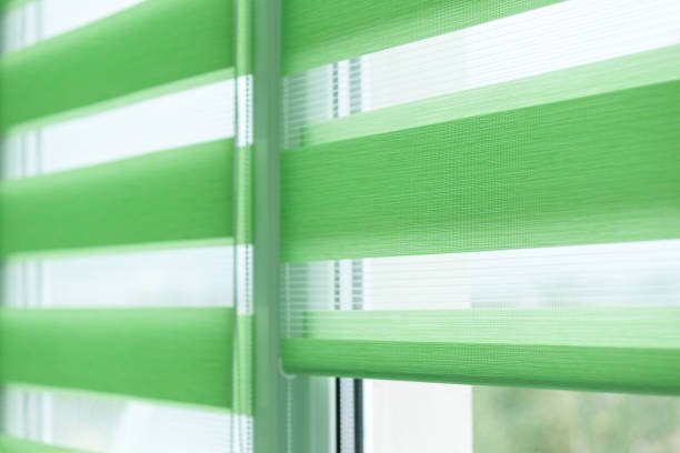 istock Close up of colored fabric roller blinds on window. Roll curtains. 1339894378