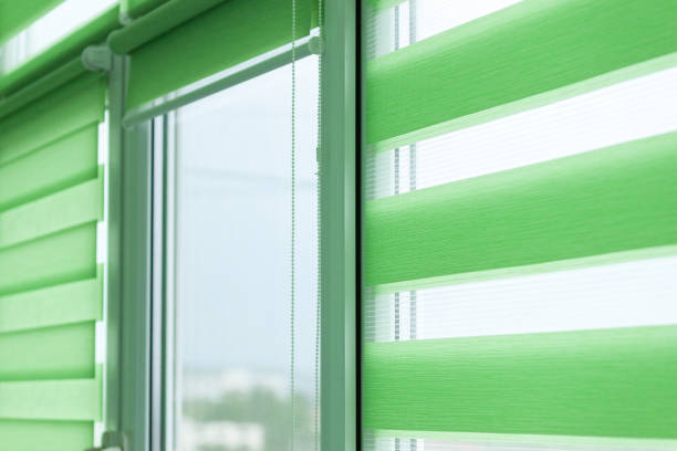 istock Close up of colored fabric roller blinds on window. Roll curtains. 1339894400