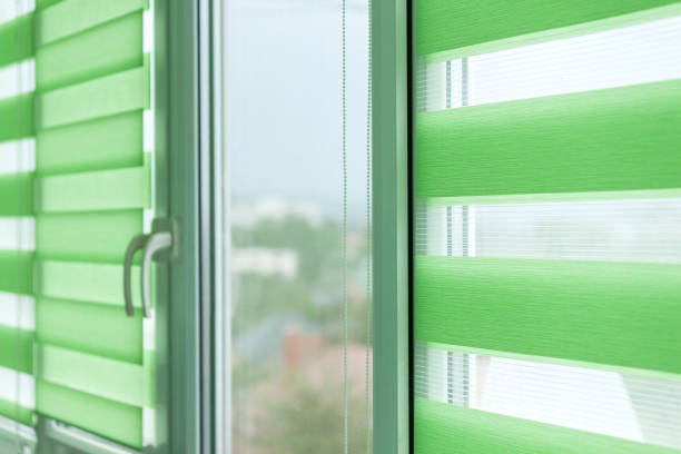 istock Close up of colored fabric roller blinds on window. Roll curtains. 1339894414