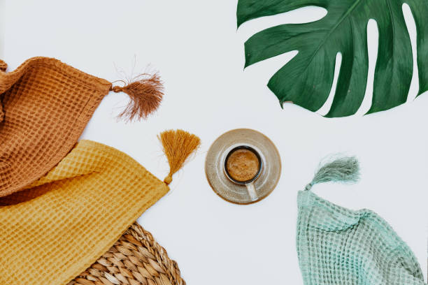 istock Two blankets, coffee cup and monstera leaf on white background, minimal simple background, workspace 1339895046