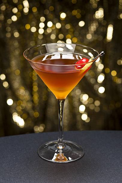 коктейль манхеттен с песочным цветом с вишней и лимонный - manhattan cocktail cocktail drink cherry стоковые фото и изображения