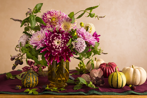 Festive table setting for Thanksgiving day. Autumnal decorations and beautiful garden flowers.