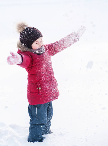istock Cute little girl has fun outdoors with snow 1339901370