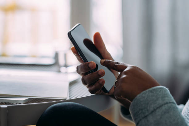 istock An Anonymous Young Businesswoman Using a Mobile Phone while Working from Home 1339901504