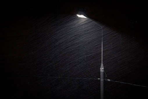 Light beam from the street lamp in heavy snow shower at night