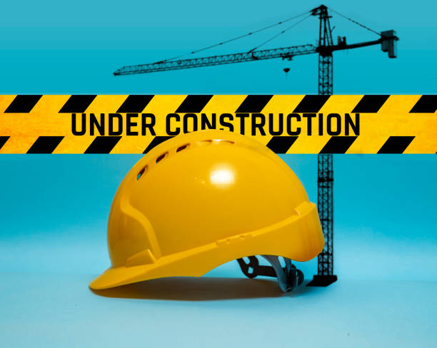 istock Under construction wallpaper, worker safety hat and crane added on graphic text 1339906196