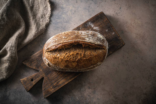 хлеб на закваске коричневый каравай домашнего немецкого стиля на разделочной доске - soda bread bread brown bread loaf of bread стоковые фото и изображения