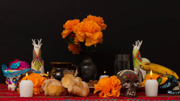 still life of a traditional day of the dead offering still life of a traditional Day of the Dead ofrenda, with a plate of Mexican food, bread, candles, skulls, alfeñique candies and fruit, altar stock pictures, royalty-free photos & images