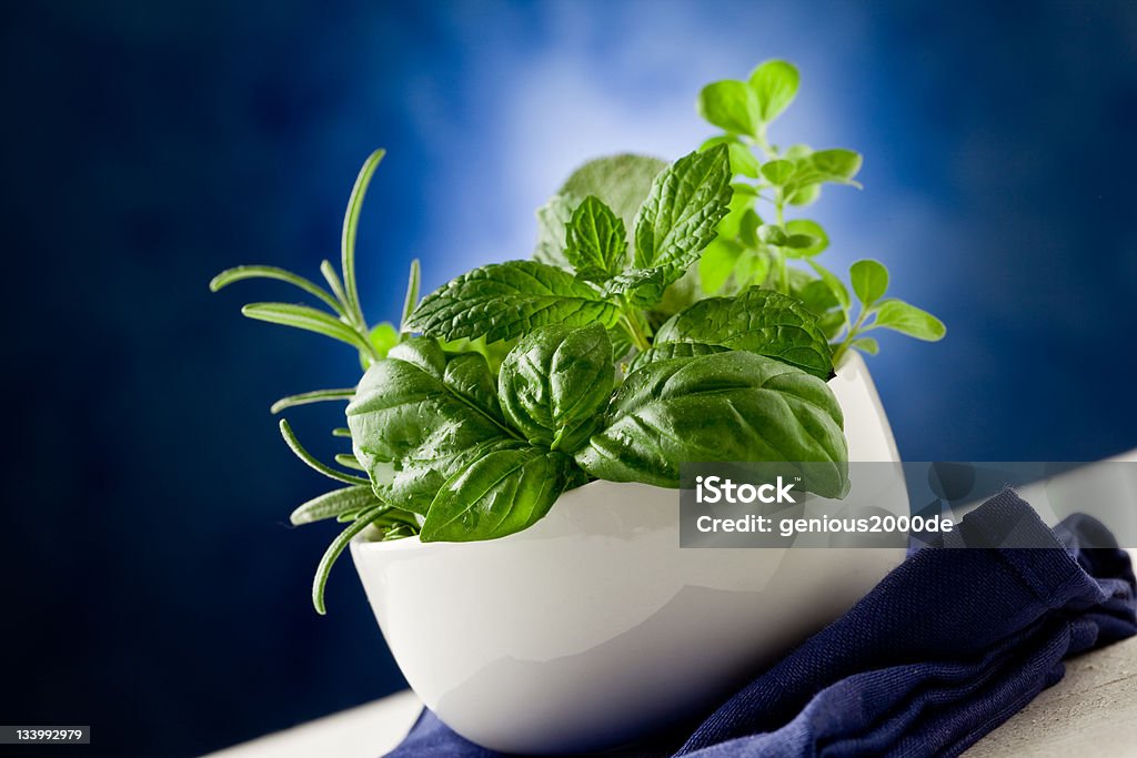 Herbs highlighted by spot light photo of delicious different herbs inside a bowl ready to be processed Basil Stock Photo