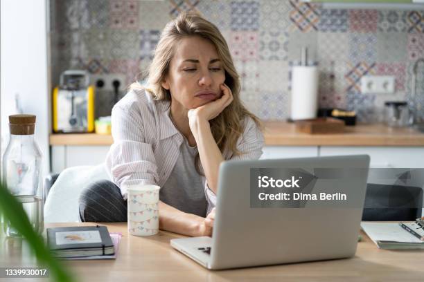 Displeased Woman Of Middle Age Search For New Job Unemployed During Covid19 Quarantine On Laptop Stock Photo - Download Image Now