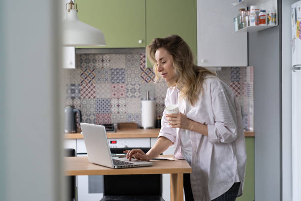 istock Businesswoman or remote worker work from home in morning read email on laptop while drinking coffee 1339930022