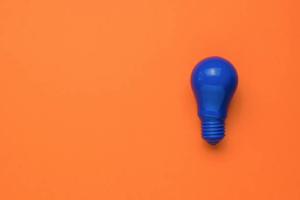 istock A bright blue light bulb on an orange background. Minimalism. Flat lay. 1339941890